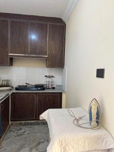 a kitchen with wooden cabinets and a bed in a room at Elysium Inn in Abbottabad