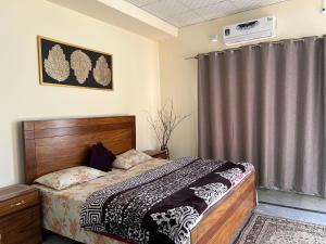 a bedroom with a bed with a wooden headboard at Elysium Inn in Abbottabad