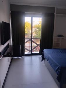 a bedroom with a bed and a door to a balcony at Eco Paradise 227 in Cumbuco