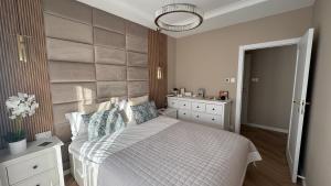 a bedroom with a bed with a large headboard at Nowoczesny Apartament Tatarska in Przemyśl