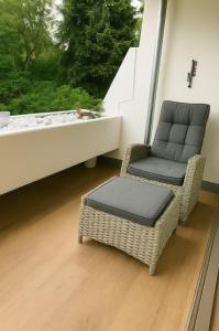 a wicker chair and a chair sitting next to a window at Apartment Ypsilon am Grün in Bayreuth