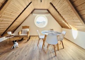 a room with a table and chairs in a attic at Psí bouda Benecko in Benecko
