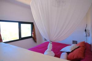 a bedroom with a bed with a curtain at Dar-west in Demina +9 photos