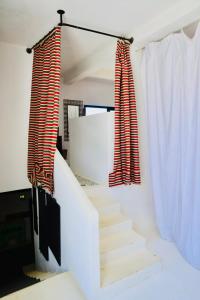 a staircase with red and white curtains in a room at Dar-west in Demina