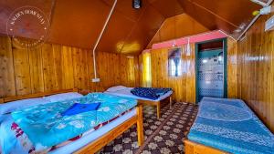 a bedroom with two beds in a wooden room at Kalden Homestay Sinji in Kalimpong