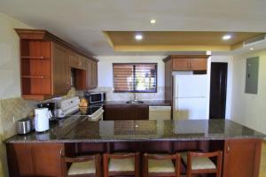 a kitchen with wooden cabinets and a counter top at Suite Esteli 114 Gran Pacifica Resort in San Diego +17 photos