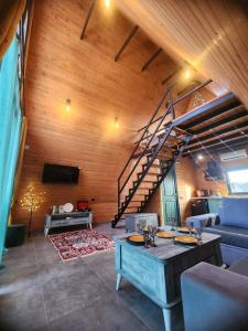 a living room with a wooden ceiling and a staircase at Day Off in Dushetʼi