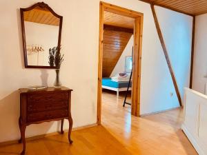 un corridoio con uno specchio e una cassettiera con un tavolo di Odw homes - charmantes Domizil im Gorxheimertal a Kunzenbach