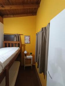 a bedroom with a bed and a yellow wall at Monoambiente in Mar de Ajó