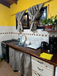 a kitchen with a sink and a stove at Monoambiente in Mar de Ajó +6 photos