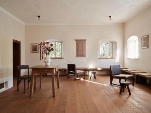 a dining room with a table and chairs and a vase of flowers at Denharten in Tann
