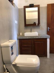 een badkamer met een wit toilet en een wastafel bij Beach House Habaraduwa in Koggala