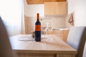a bottle of wine sitting on a table with two wine glasses at Biser Kupresa 2 in Kupres