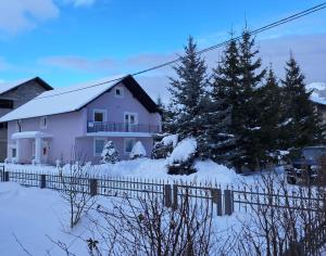 a white house with a fence in the snow at Biser Kupresa 2 in Kupres