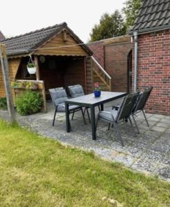 a picnic table and chairs in a backyard at Ferienhaus Seestern in Dornum