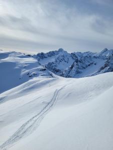 a snow covered mountain with ski tracks in the snow at Chambre double privée in Martigny-Ville