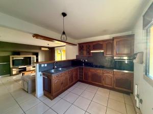 a kitchen with wooden cabinets and a sink at Apartment with exceptional views, Saint-Joseph in Saint-Joseph