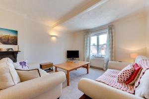a living room with two couches and a table at 3 Bed in Woodbridge oc-tst in Melton +4 photos