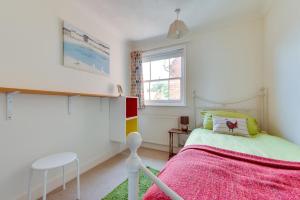 a bedroom with a bed and a table and a window at 3 Bed in Woodbridge oc-tst in Melton