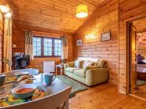 una baita di tronchi con soggiorno, divano e tavolo di 1 Bed in Higher Clovelly 00355 a Clovelly