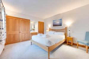 a bedroom with a bed and a chair in it at 2 Bed in Southwold oc-weh in Southwold