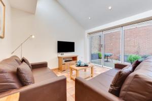 a living room with a couch and a television at 2 Bed in Southwold oc-weh in Southwold