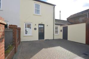 a white house with a black door and a driveway at 2 Bed in Southwold oc-weh in Southwold