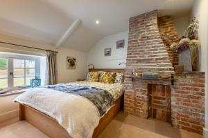 a bedroom with a brick fireplace and a bed at 2 Bed in Heacham oc-2013 in Heacham
