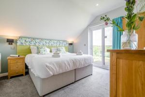 a bedroom with a large bed and a vase with flowers at 6 Bed in Winnards Perch oc-t29966 in Saint Columb Major +47 photos