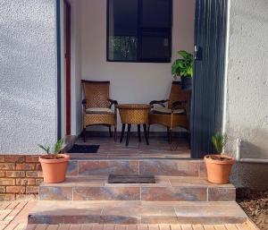 a patio with wicker chairs and a table at Moya Guesthouse in Johannesburg