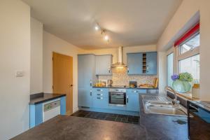 a kitchen with blue cabinets and a sink at 3 Bed in Morfa Nefyn oc-wag720 in Morfa Nefyn