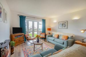 a living room with a blue couch and a tv at 3 Bed in Morfa Nefyn oc-wag720 in Morfa Nefyn