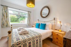 a bedroom with a bed and a mirror and a window at 3 Bed in Morfa Nefyn oc-wag720 in Morfa Nefyn