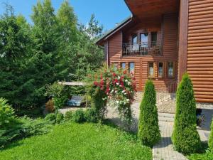 een huis met een tuin met struiken en bomen bij Pryvitannya Sontsyu in Skhidnitsa