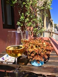 a glass of wine and a flower arrangement on a table at Apartamento Porto Baixa in Porto