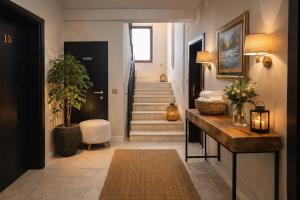 a hallway with a staircase with a table and a rug at Plitvice Falls Cottage - Luxury rooms & Dinner in Plitvica Selo