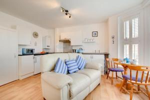 a living room with a white couch and a kitchen at 1 Bed in Sheringham oc-2033 in Sheringham