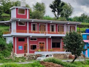 a red house with a car parked in front of it at Hill Side Heaven Homestay in Nainital