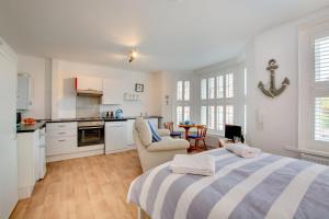 a bedroom with a large bed and a kitchen at 1 Bed in Sheringham oc-2033 in Sheringham