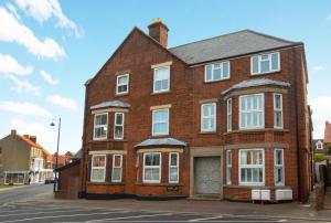 a red brick house with white windows on a street at 1 Bed in Sheringham oc-2033 in Sheringham