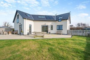a white house with solar panels on the roof at 4 Bed in Aberarth oc-g30835 in Aberaeron