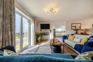 a living room with a blue couch and a large window at 4 Bed in Aberarth oc-g30835 in Aberaeron