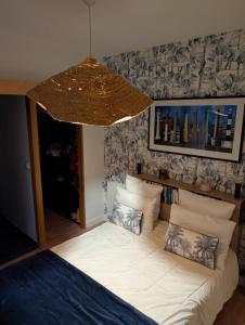 a bedroom with a bed and a chandelier at Maison de la Vicomté in Dinard +4 photos