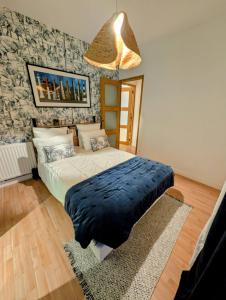 a bedroom with a bed with a blue blanket on it at Maison de la Vicomté in Dinard