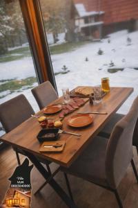 a wooden table with plates of food on it at Villa WOLF in Divčibare