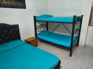 a room with two bunk beds and a chair at Hotel Escocia in Estación El Salto