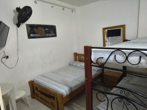 a room with two bunk beds and a tv at Hotel Escocia in Estación El Salto