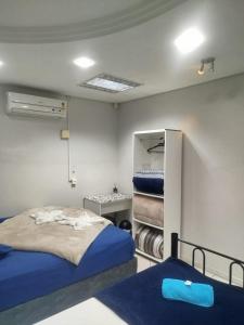 a bedroom with two beds and a closet at Pousada Central Quarto 1 in Joinville