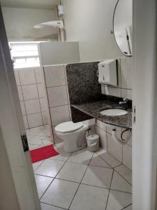 a small bathroom with a toilet and a sink at Pousada Central Quarto 1 in Joinville