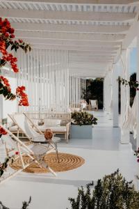 a white room with a chair and a table at Herdade D’ Amoreira Aljezur in Aljezur